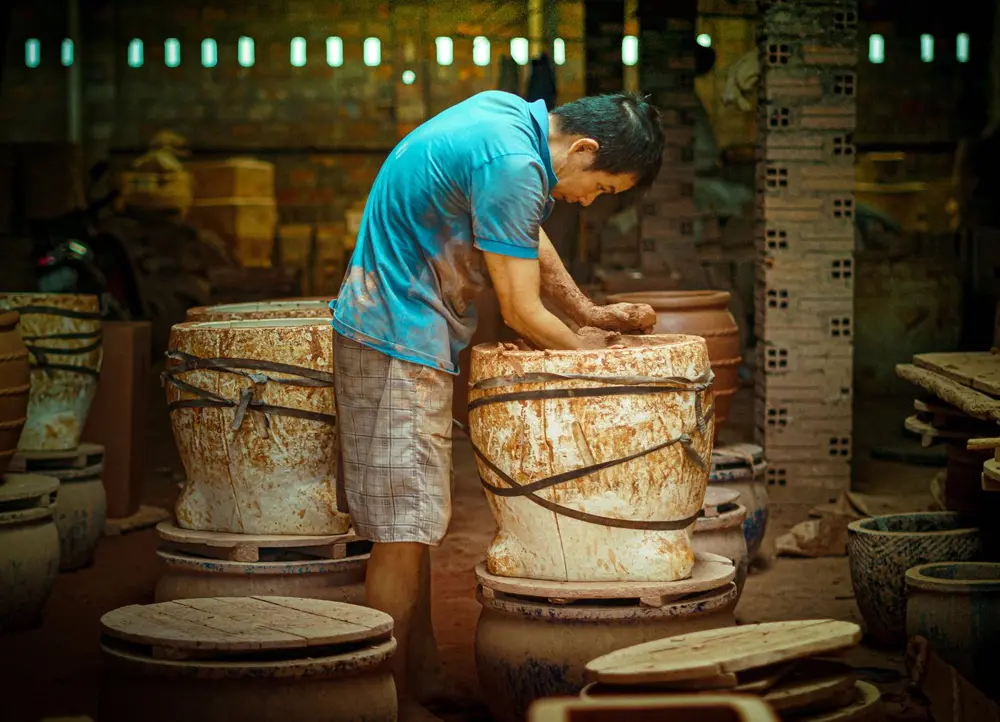 Potter shaping a large pot on a wheel in Ho Chi Minh City